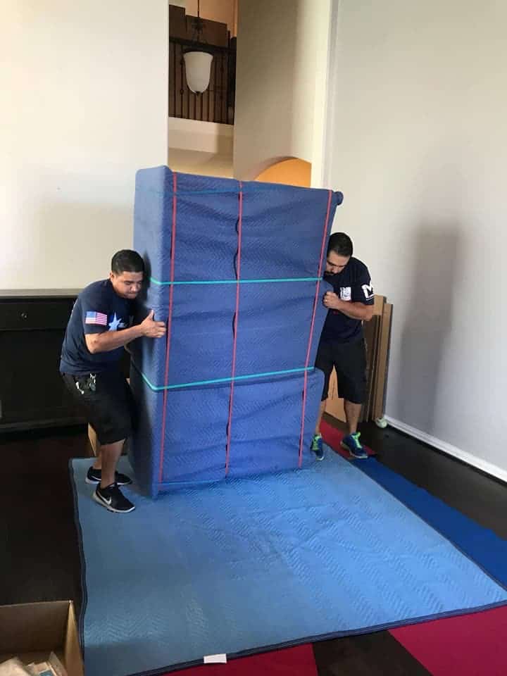 two movers trying to lift a huge furniture