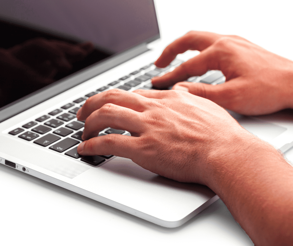 photo of a hand typing on a laptop