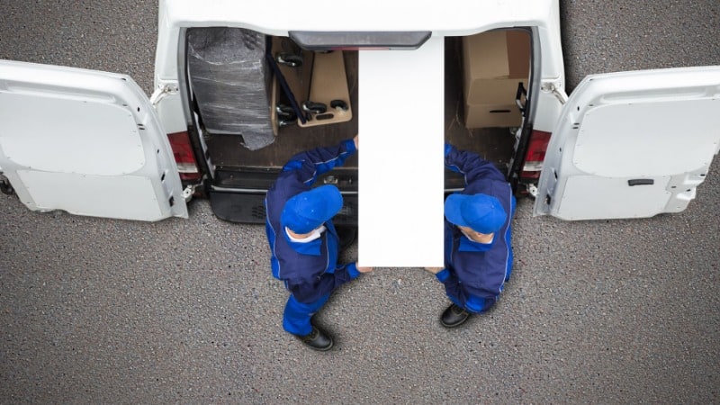 two-guys-carring-a-cabinet-to-a-truck