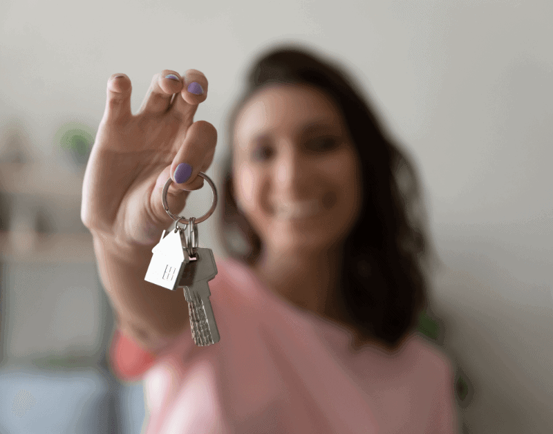 a woman holding a key to a new home