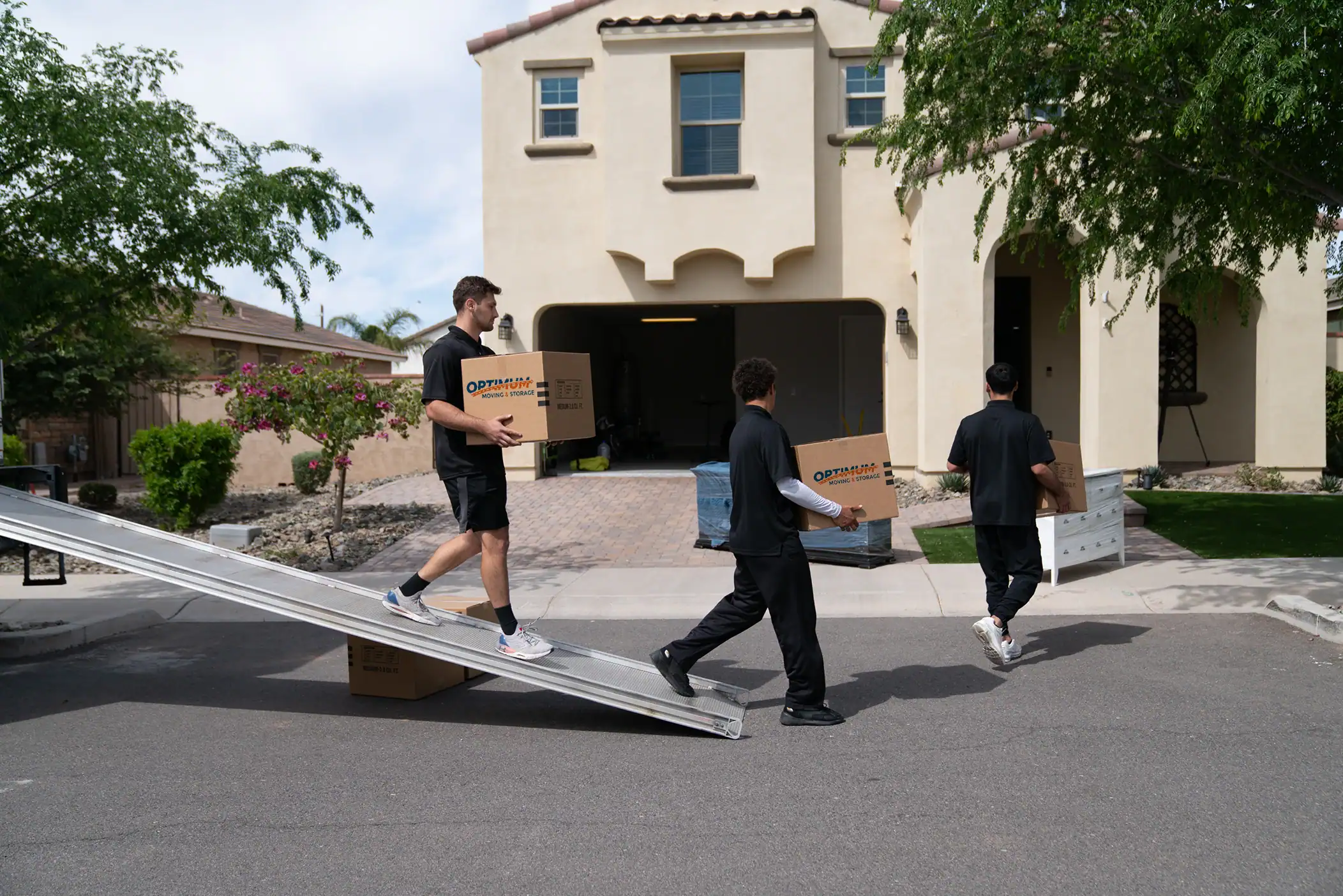 Professional movers handling residential moving services in a suburban neighborhood.